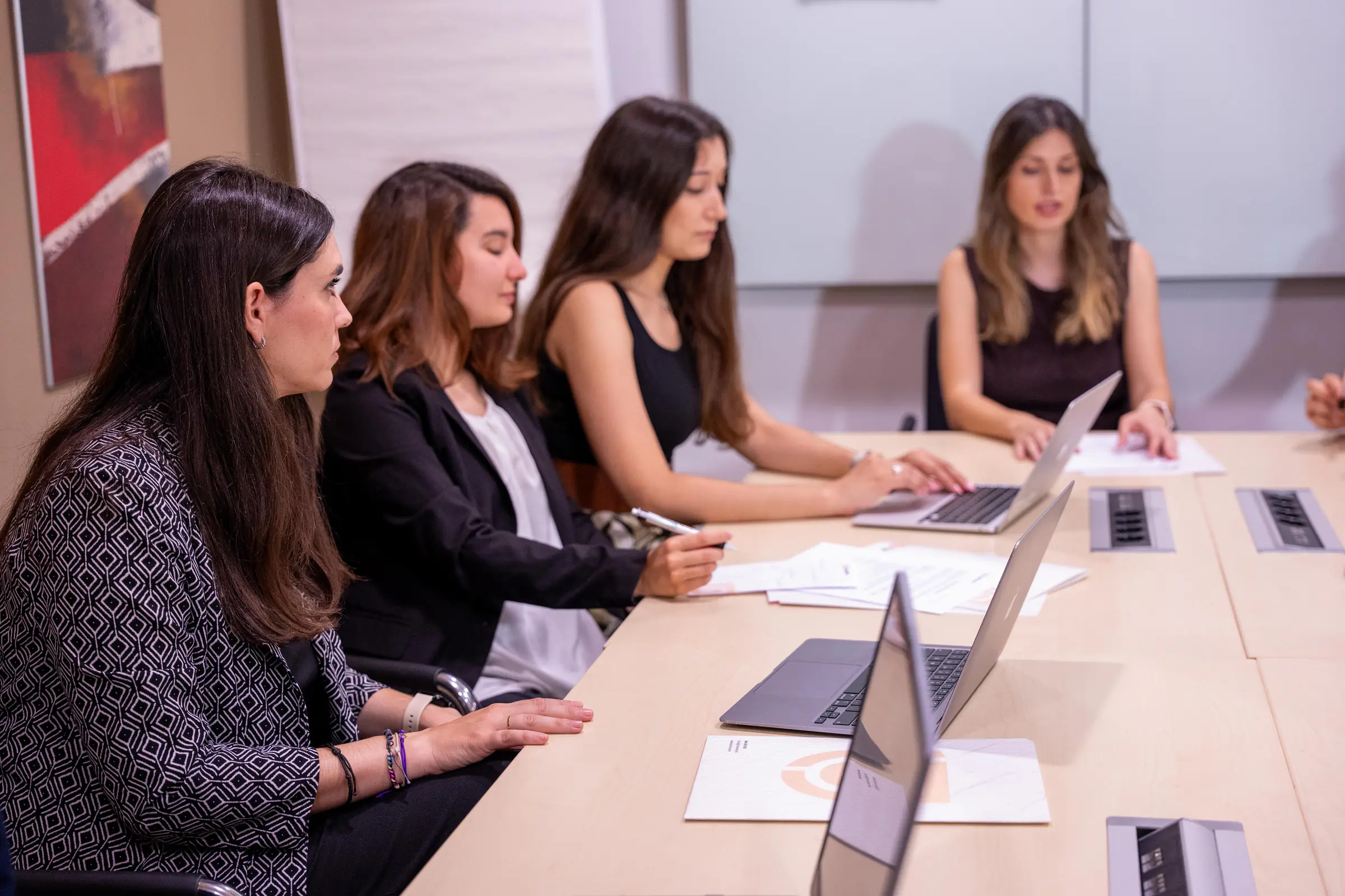 Cuatro compañeras del equipo en una reunión con portátiles